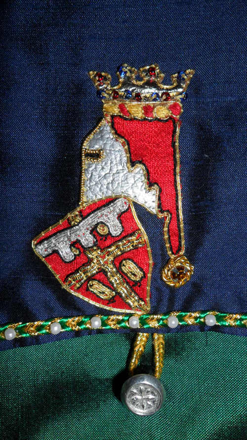 Detail of Ancient Heraldic device for the first born son of Sir Justyn in Goldwork . Helm in Silver leather with Silk Mantle. Duke's Coronet in Gold Kid leather